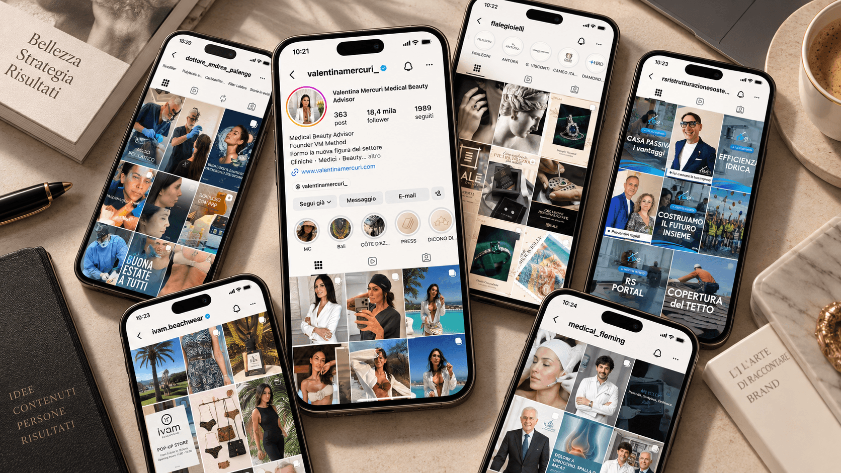 Smartphone con profili Instagram professionali disposti su una scrivania accanto a libri e caffè.