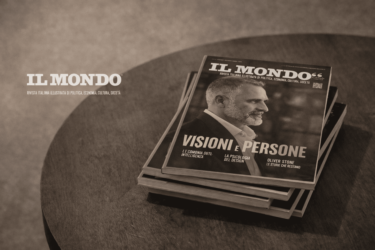 Riviste Il Mondo impilate su un tavolo di legno con copertina Visioni e Persone.